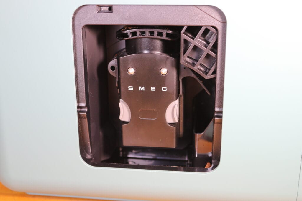 La cafetière expresso avec broyeur SMEG BCC13. En détail, le réservoir à grains de café. Le bloc d'extraction