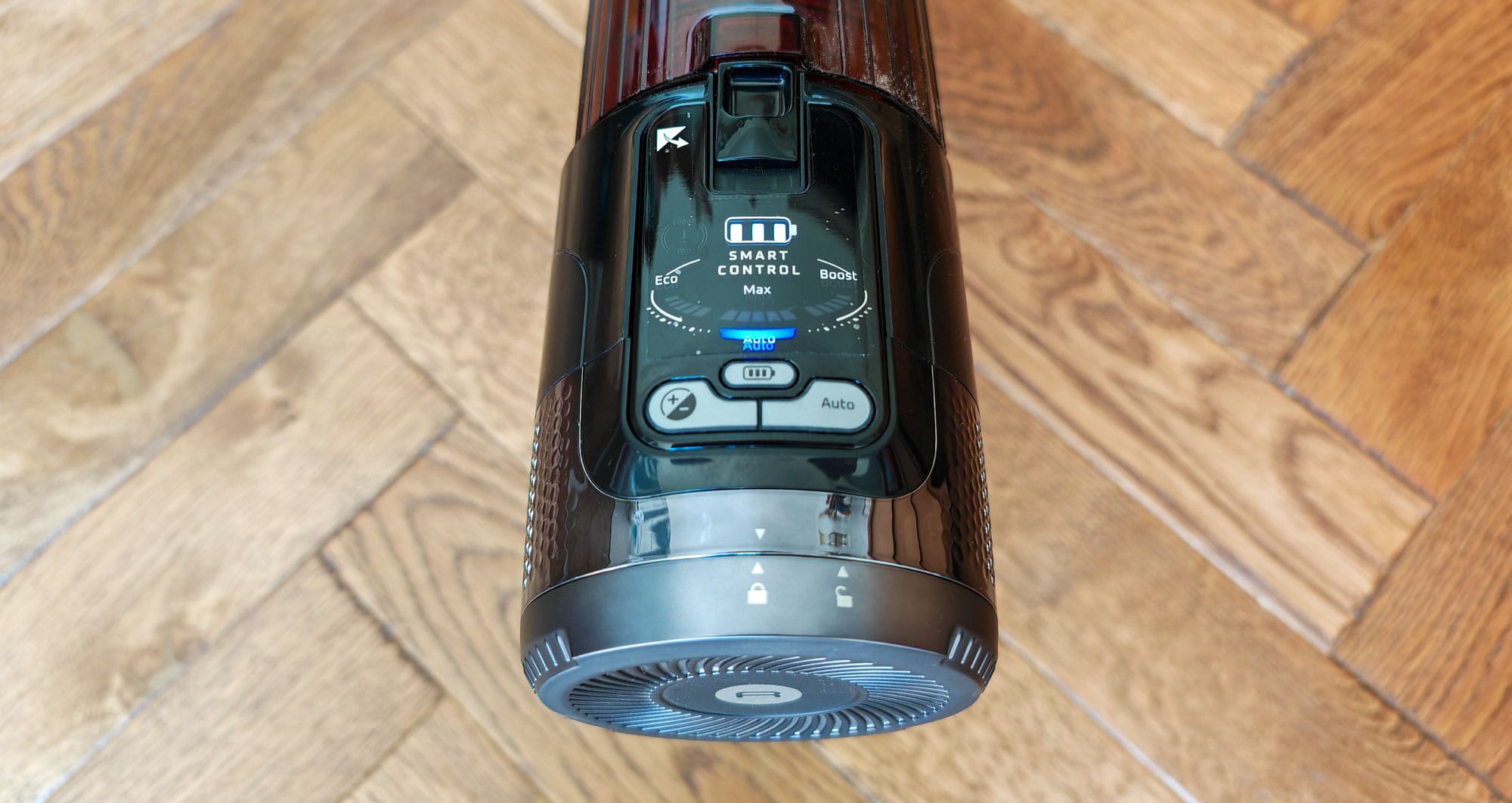 Le panneau de commande affiche le niveau de batterie sur trois niveaux. Par défaut, l'aspirateur est en mode automatique. Il est possible de forcer le mode Eco, standard ou boost en appuyant sur le bouton (+/-). (c) Labo maison