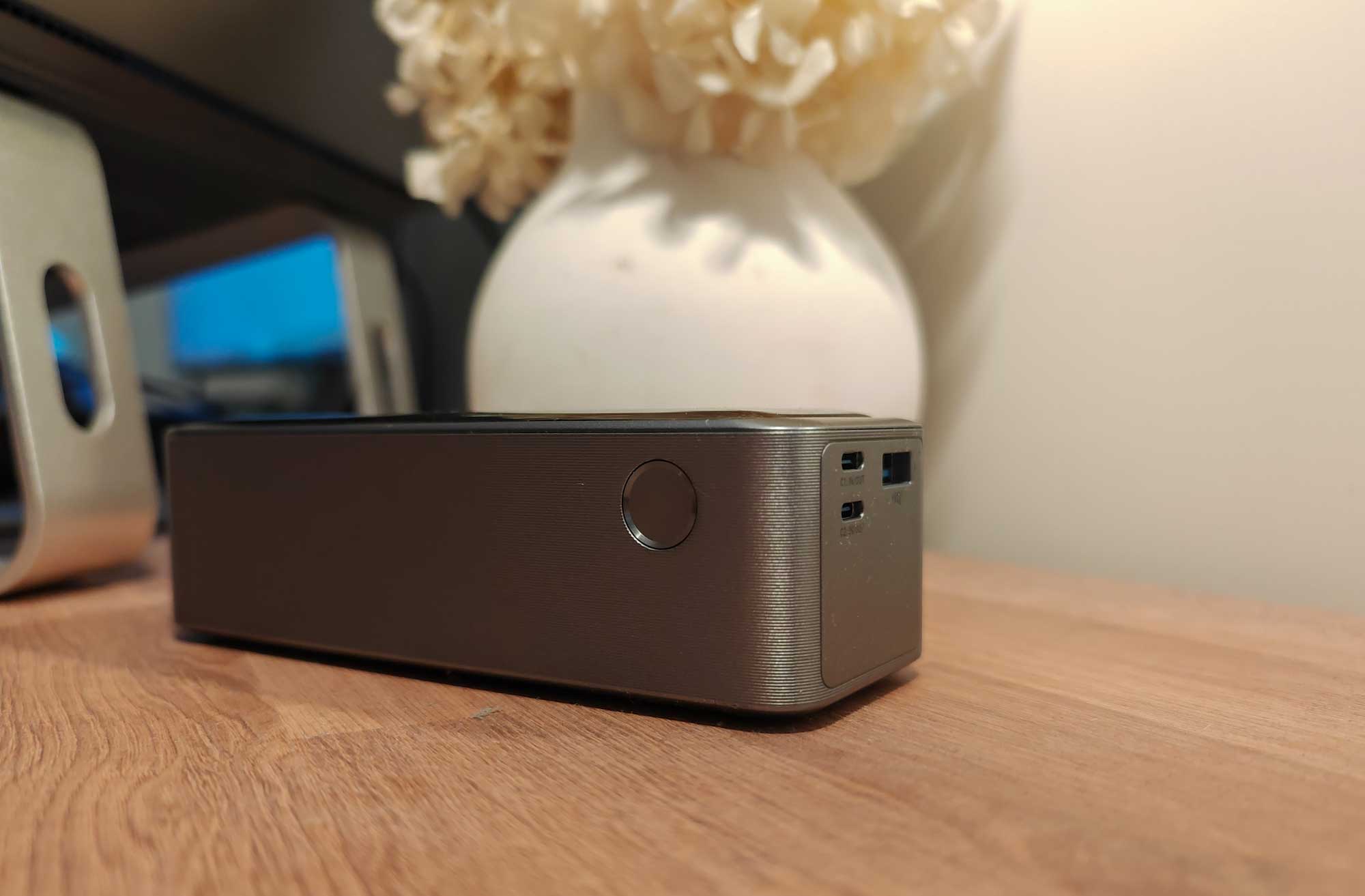Pour allumer la batterie externe, appuyez sur le bouton marche/arrêt situé sur le côté. L’écran s’illuminera, indiquant le niveau de charge actuel et la puissance en cours de distribution. (c) Labo Maison