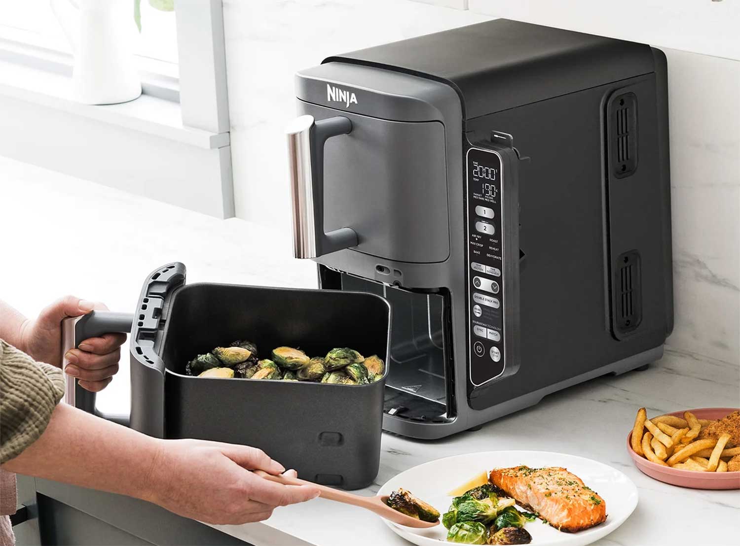 L'Airfryer Ninja Double Stack XL 9,5 L SL451EU dispose de deux tiroirs empilés de 4,75 L chacun, avec résistances et ventilateurs indépendants. Grilles incluses pour cuire sur deux niveaux par tiroir, offrant ainsi quatre niveaux de cuisson tout en optimisant l'espace.