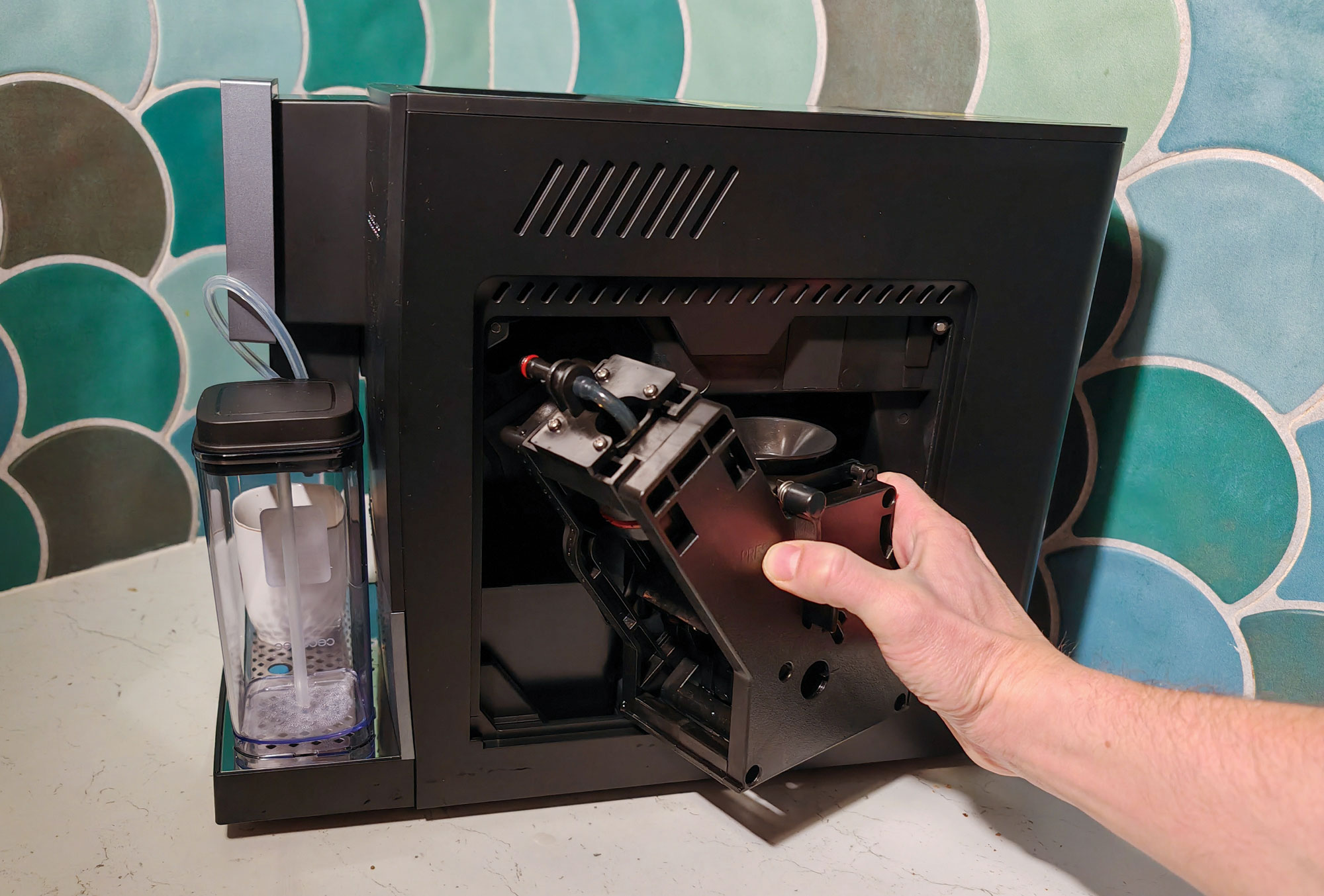 L'infuseur de la Cecotec Cremmaet Compactccino Connected est accessible derrière la trappe située à droite de la machine, facilitant ainsi son nettoyage. (c) Labo Maison