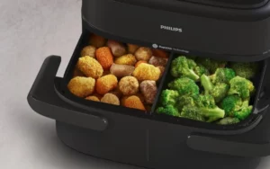 Philips Air Fryer Série 1000 en gros plan avec son tiroir ouvert et ses deux compartiments en cuisson.