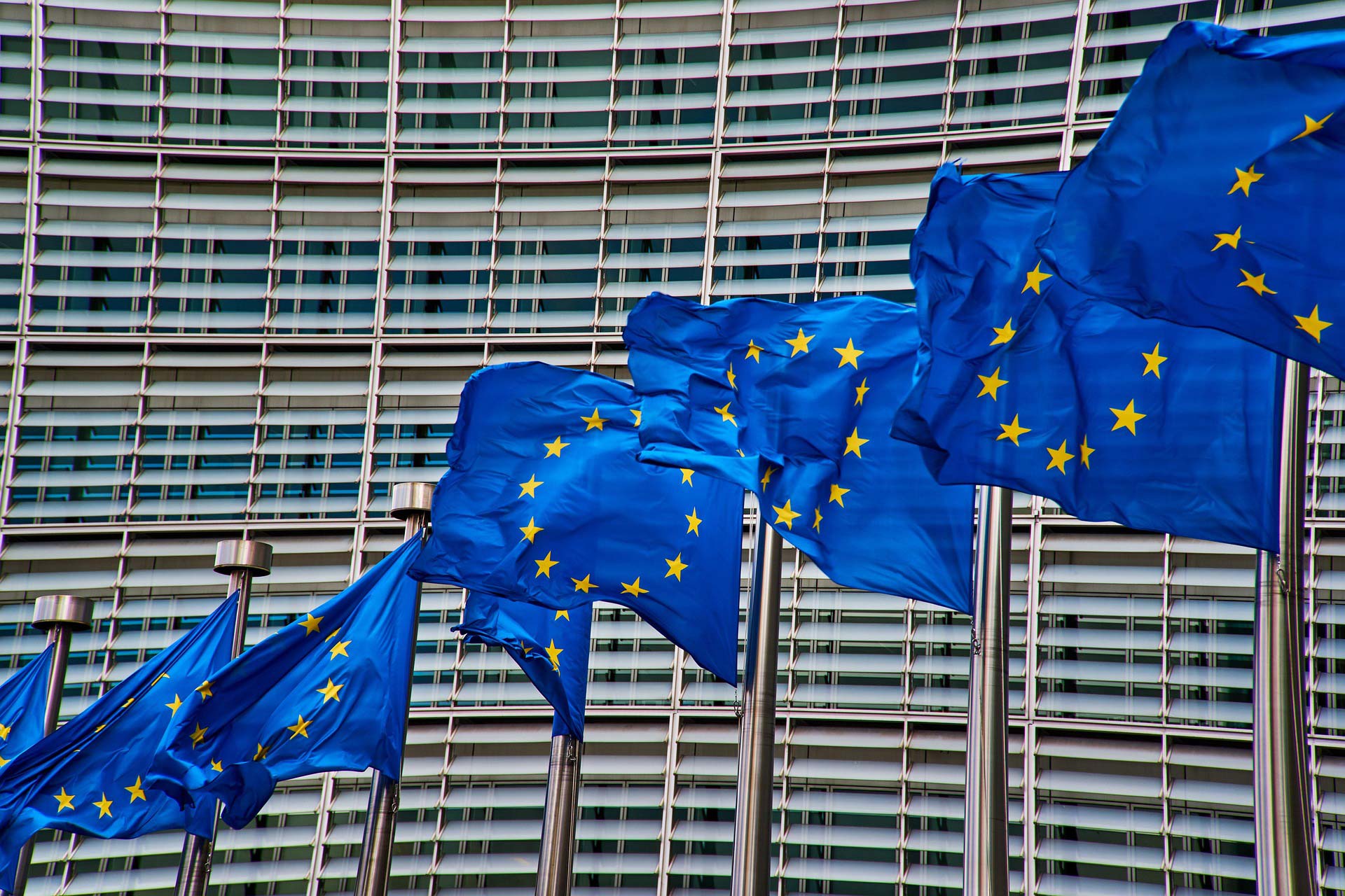 Drapeau de l’Union européenne flottant devant un bâtiment institutionnel